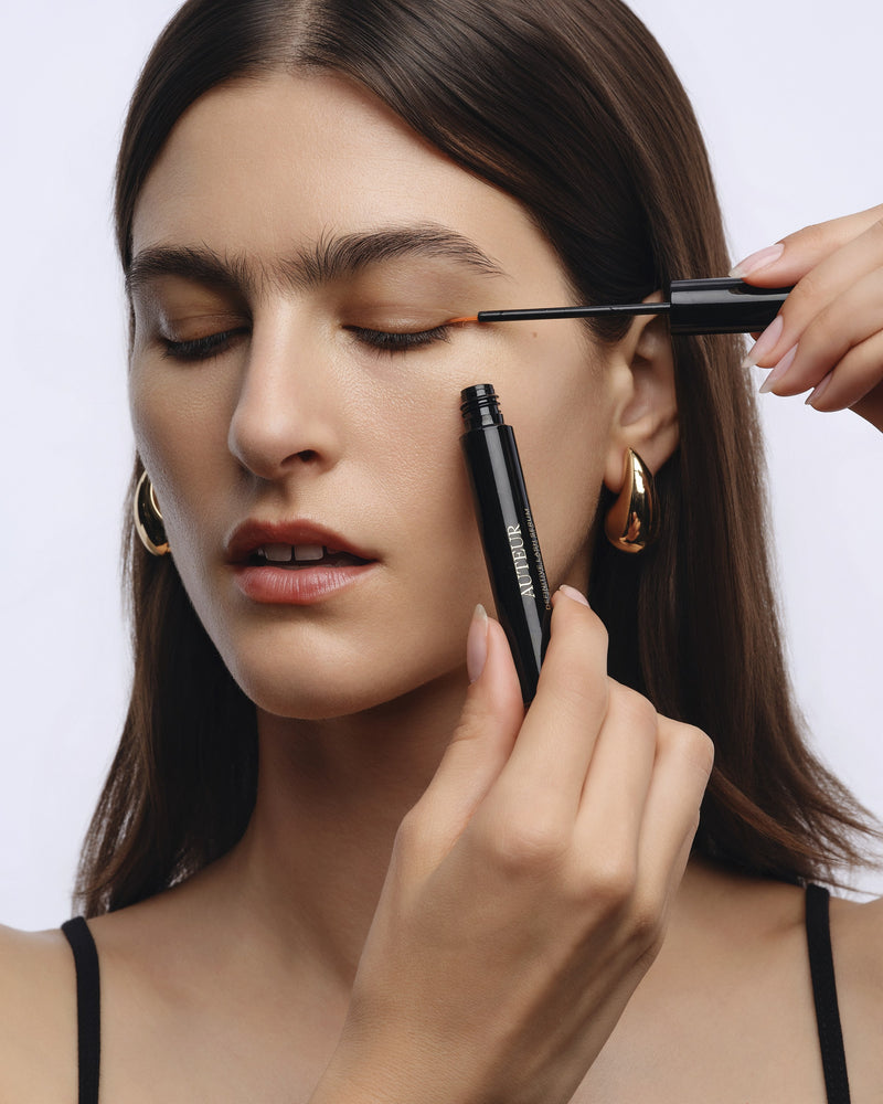 Applying Definitive Lash Serum along the upper lash line