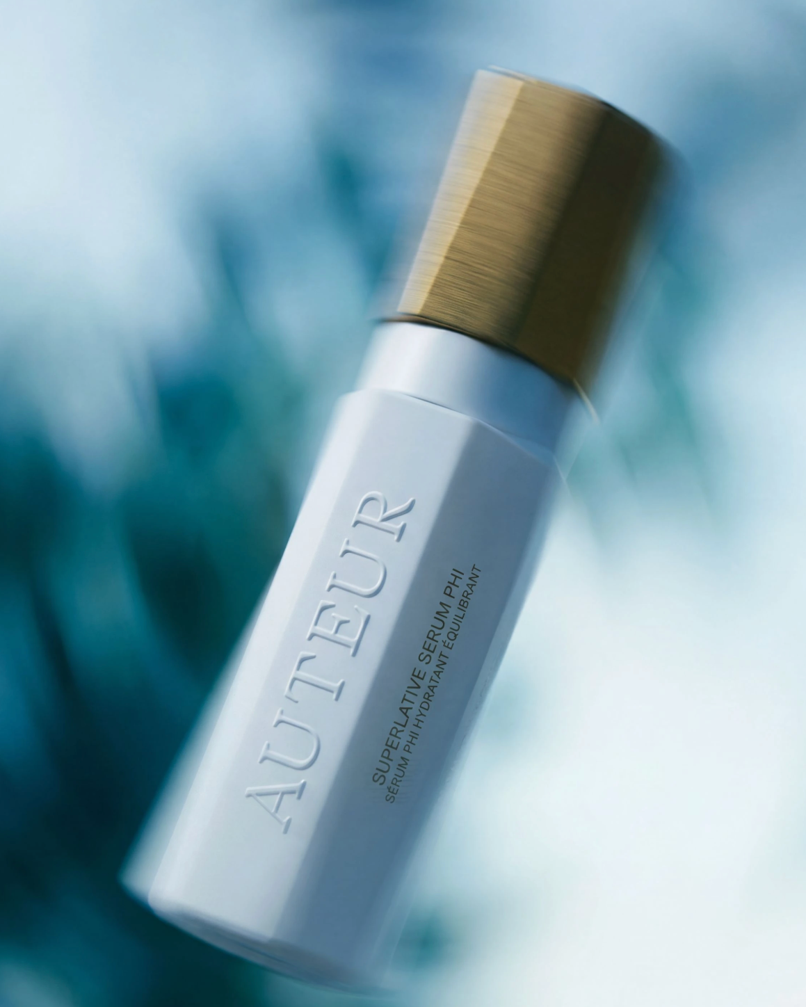 Skincare bottle labeled 'Auteur' with a blurred natural background