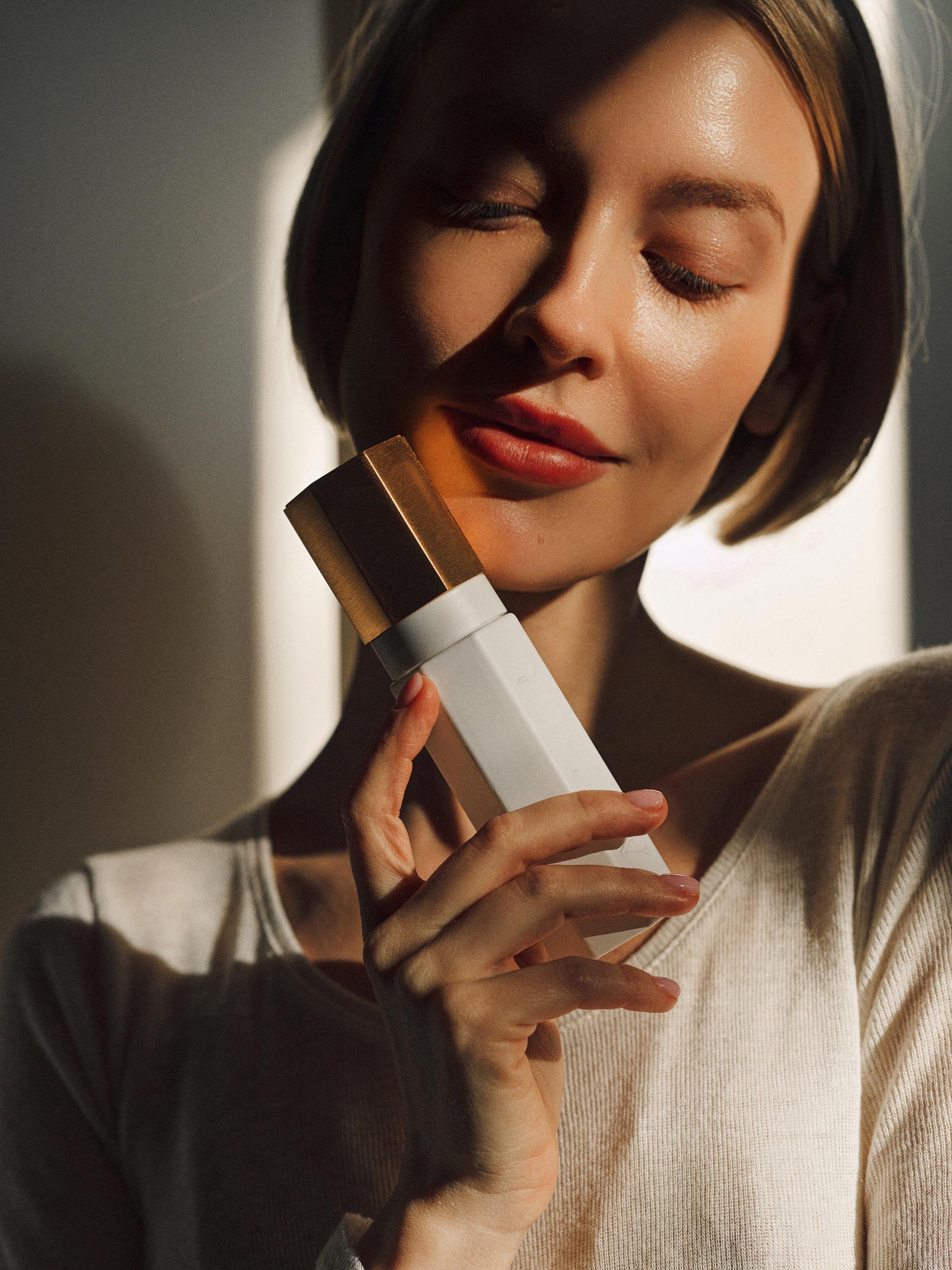 Woman holding a skincare product with a blurred background