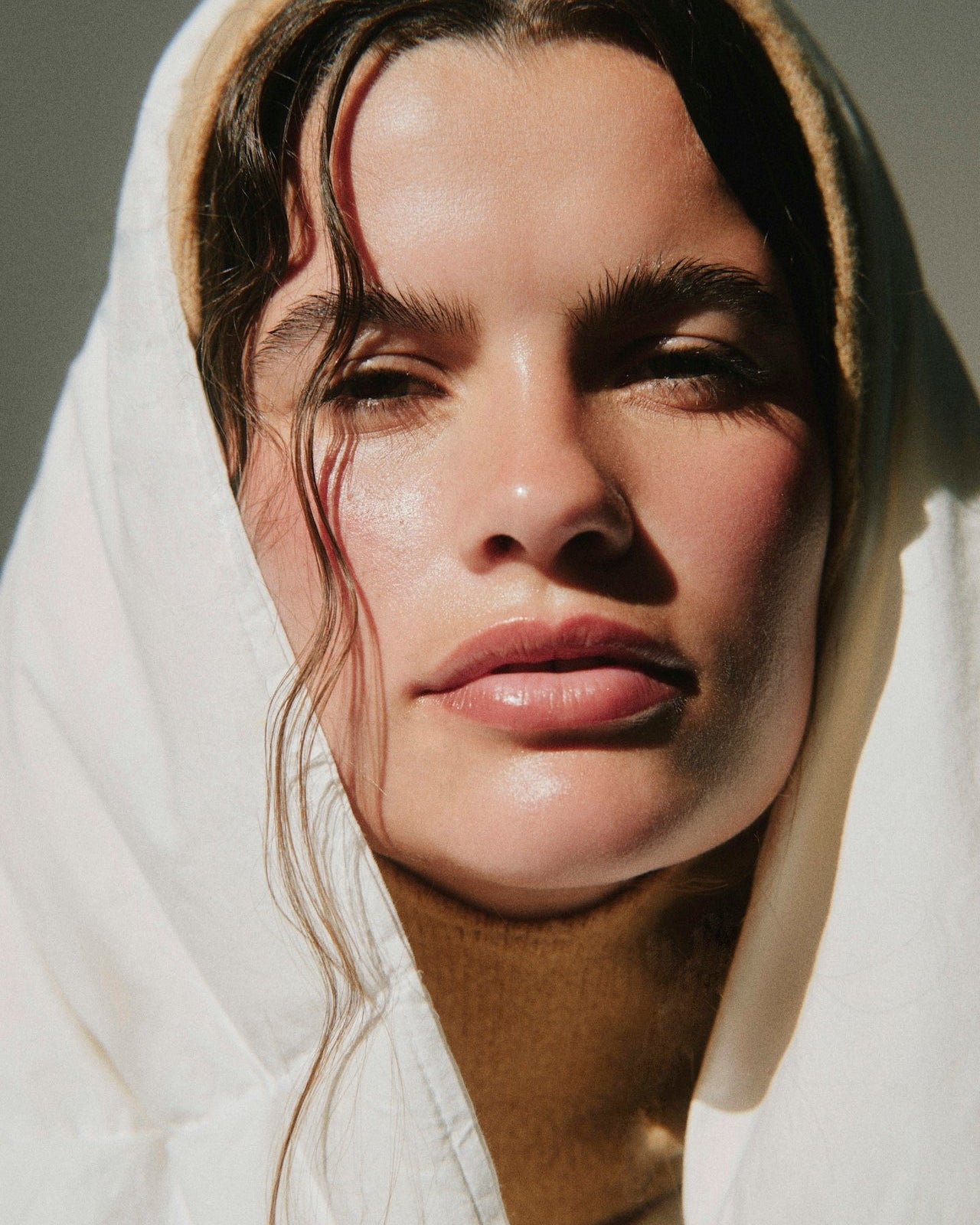 Close-up of a woman wearing a white headscarf with a neutral background
