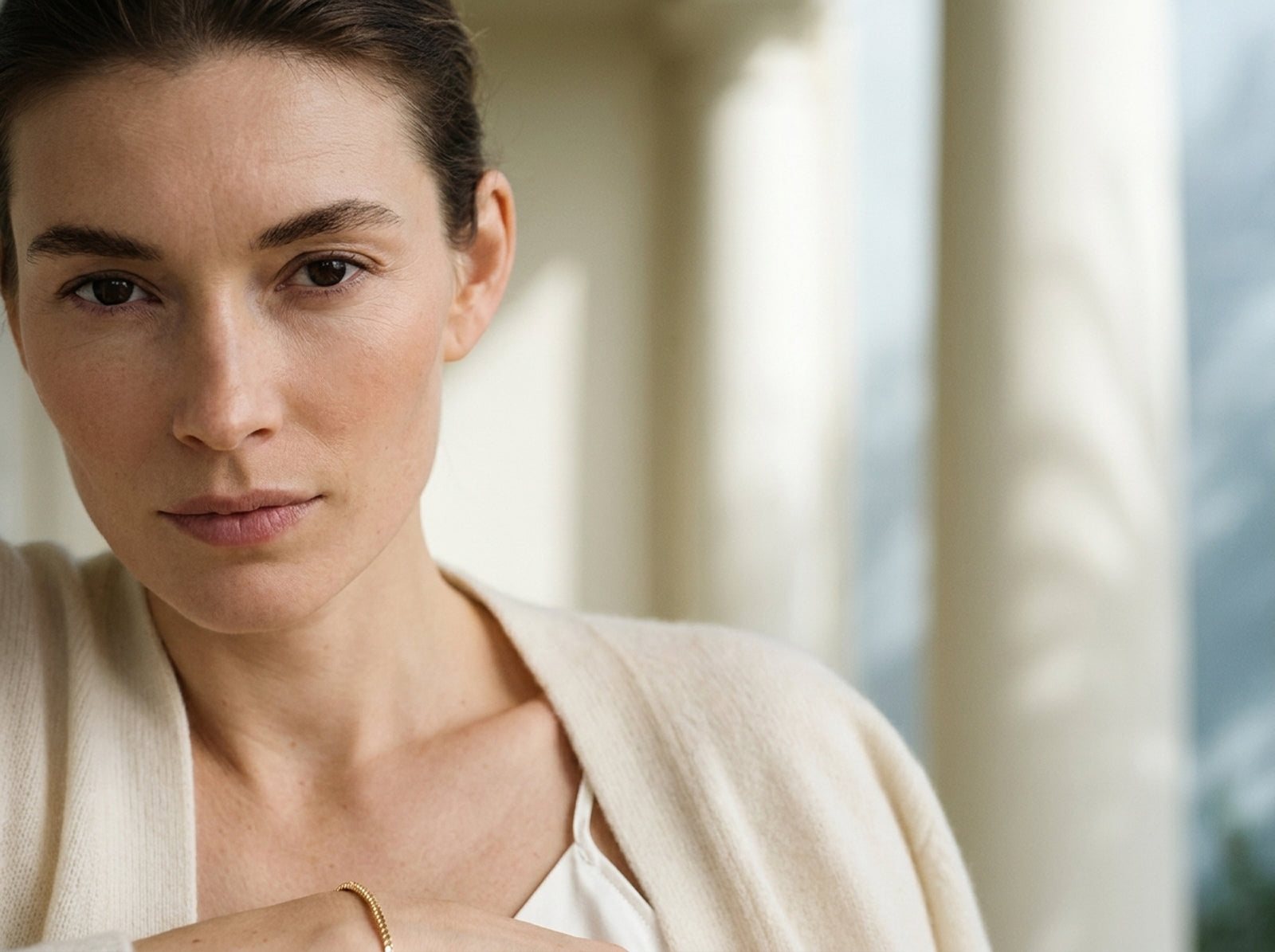 Woman wearing a beige cardigan in a softly lit indoor setting