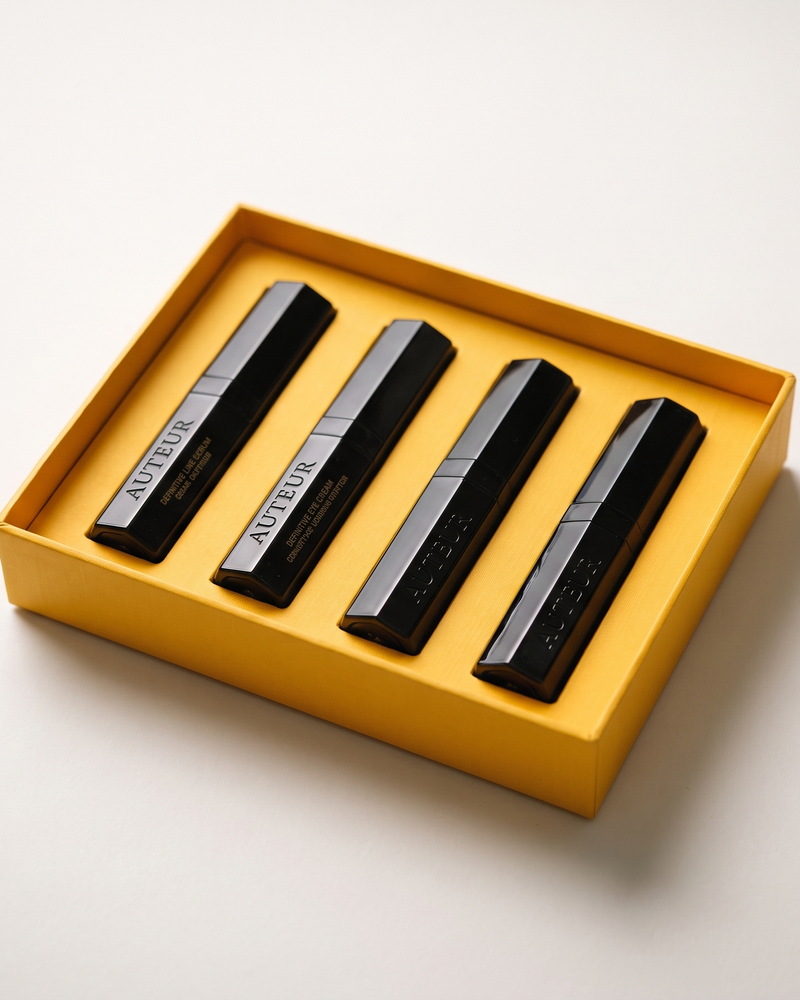 Four black vape devices with silver accents arranged inside a yellow box on a light gray background.
